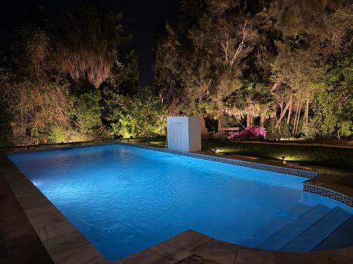 a swimming pool in a garden at night at La Pinta Golf Villa Sotogrande in Sotogrande