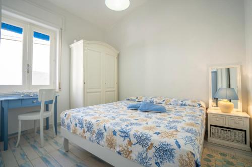 a bedroom with a bed and a desk and a table and chair at I Gradini sul Mare in Santa Maria