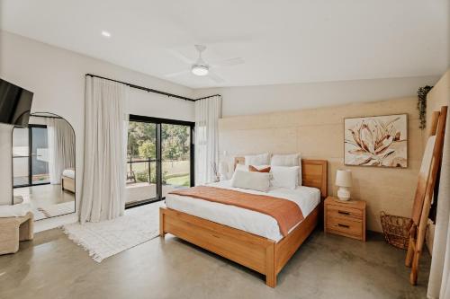 a bedroom with a bed and a large window at Wildwood Retreat a Luxury Vineyard Escape in Yallingup Siding