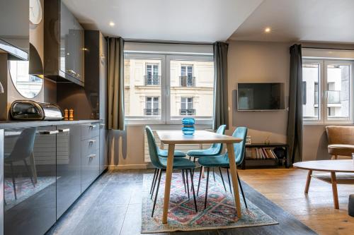 une cuisine et une salle à manger avec une table et des chaises dans l'établissement Les Appartements Cardinet, à Paris