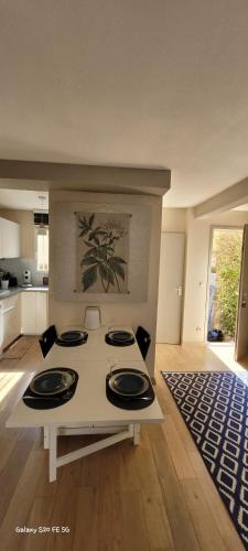 une cuisine avec une table et 4 assiettes. dans l'établissement Valras-Loc Le Bonheur a la Plage, à Valras-Plage