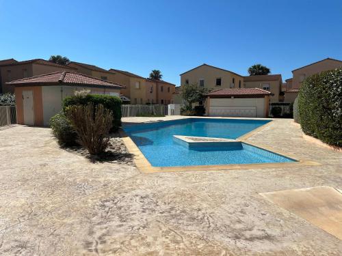une piscine au milieu d'une cour dans l'établissement Valras-Loc Le Bonheur a la Plage, à Valras-Plage