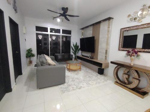 a living room with a couch and a flat screen tv at Homestay Naaila, Alor Gajah in Kampong Jelatang