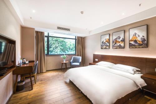 a hotel room with a large bed and a desk at Youmi Hotel-Chongqing Hongyadong Chaotianmen in Chongqing