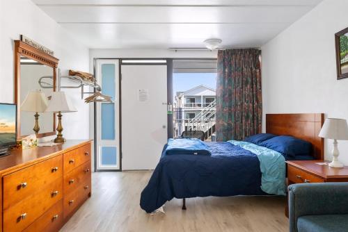 a bedroom with a bed and a balcony at 313 E Glenwood Ave, Unit 109 in Wildwood