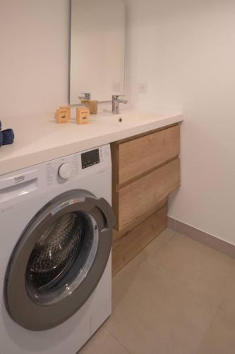 une machine à laver dans une salle de bain avec un lavabo dans l'établissement 66 Suite A108, à Valras-Plage
