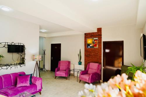 a living room with pink chairs and a tv at Shale Tsagveri in Tsaghveri