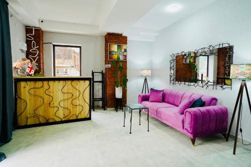 a living room with a purple couch and a table at Shale Tsagveri in Tsaghveri