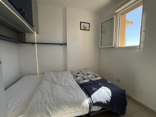 une chambre avec un lit dans une pièce avec une fenêtre dans l'établissement Belle appartement vue mer, à Valras-Plage