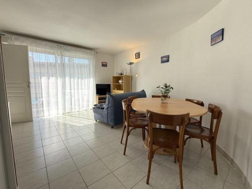 un salon avec une table et des chaises en bois dans l'établissement Belle appartement vue mer, à Valras-Plage