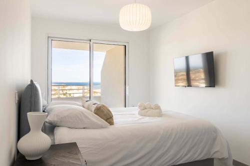 une chambre blanche avec deux lits et une fenêtre dans l'établissement Panarea 903, à Valras-Plage