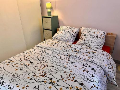 a bedroom with a bed with a white comforter at Maison Sympa in Valras-Plage