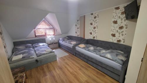 a living room with two couches and a window at Penzión Korzo in Štúrovo