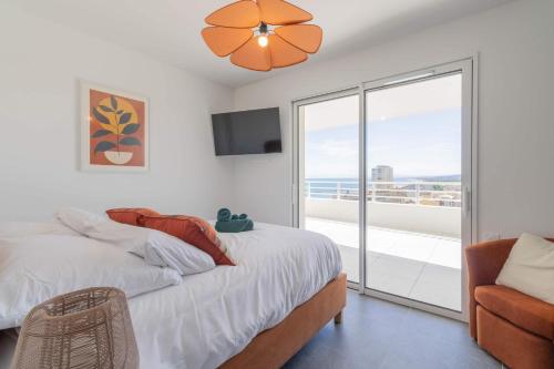 une chambre avec un lit et une télévision et un balcon dans l'établissement Panarea 902, à Valras-Plage