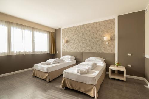 a hotel room with two beds and a window at Blue Dream Hotel in Monselice