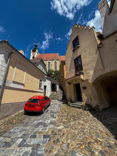 a red car parked in front of a building at Danube Holiday Homes Top 5 in Krems an der Donau