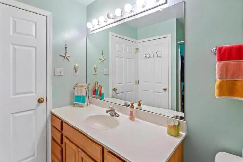a bathroom with a sink and a mirror at Gorgeous 3 Bedroom Condo with Ocean Views & Garage Parking in Wildwood
