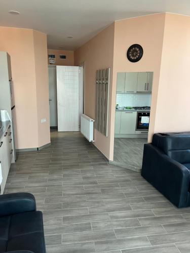 a living room with couches and a clock on the wall at აპარტამენტი ქობულეთში апартамент в Кобулети apartment in Kobuleti in K'obulet'i