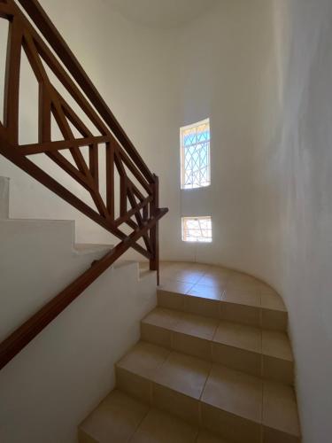 a staircase with a wooden railing and a window at 毛里求斯民宿 in Roche Bois