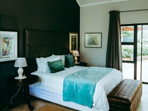 a bedroom with a large white bed with green pillows at Galloway Guest House in Robertson