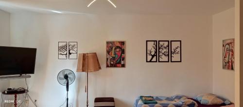 a living room with a tv and some pictures on the wall at BORNE militaria wygodne mieszkanei dla 5 osób in Borne Sulinowo