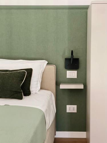 a bedroom with a bed and a green wall at Maderni Loft in Como
