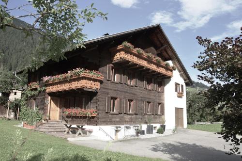 une maison en bois avec des jardinières à l'avant dans l'établissement Appartements Rudigier, à Gaschurn