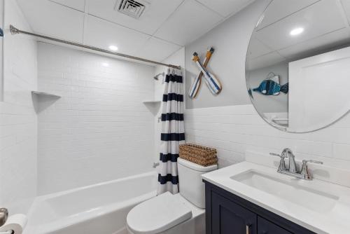 Un baño con lavabo, inodoro y espejo. en 301 Ocean Ave, Unit 217 - The Harbor Light, en North Wildwood