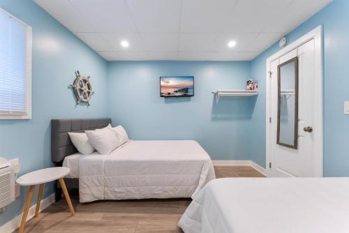 two beds in a room with blue walls at 301 Ocean Ave, Unit 109 - The Harbor Light in North Wildwood