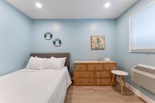 a bedroom with a bed and a table and a window at 301 Ocean Ave, Unit 109 - The Harbor Light in North Wildwood