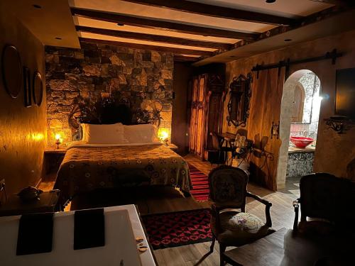a bedroom with a bed and a stone wall at Vila Eden Boutique Hotel in Korçë
