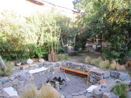a garden with a bench and a stone wall at Hotel Boutique Terra Diaguita & Spa in La Serena