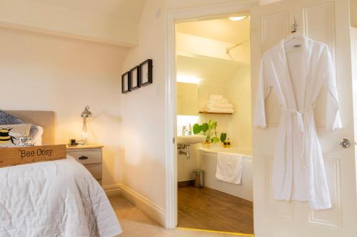 a bedroom with a white robe hanging on a door at The Hive at 52 in Northwich