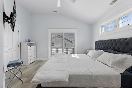 a white bedroom with a large bed and a window at 225 E Youngs Ave, Unit A in Wildwood