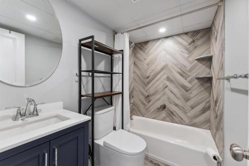 a bathroom with a sink and a toilet and a mirror at 301 Ocean Ave, Unit 204 - The Harbor Light in North Wildwood