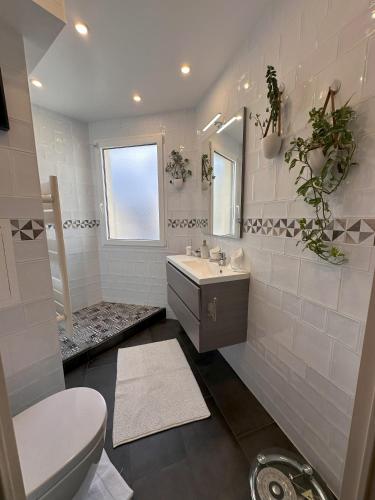 une salle de bain blanche avec un lavabo et des toilettes dans l'établissement Issy - les jardins du séminaire, à Issy-les-Moulineaux
