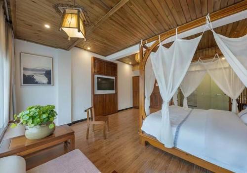 a bedroom with a canopy bed with a wooden ceiling at Huazhu Xizhou Impression Inn Furong Town Waterfall Branch in Wang-ts'un