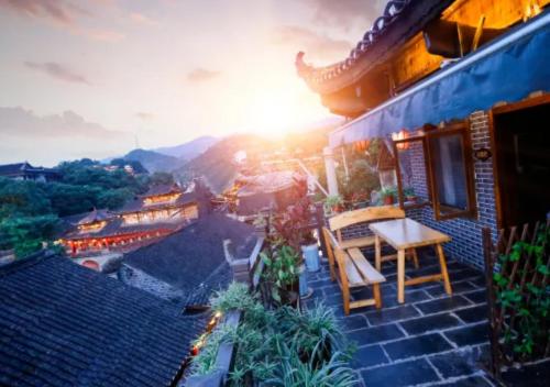 a balcony of a house with a table and chairs at Huazhu Xizhou Impression Inn Furong Town Waterfall Branch in Wang-ts'un