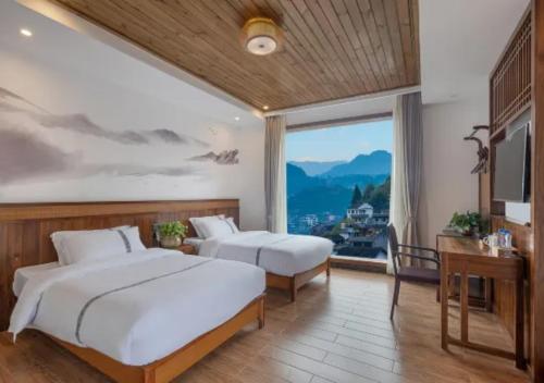 a hotel room with two beds and a large window at Huazhu Xizhou Impression Inn Furong Town Waterfall Branch in Wang-ts'un