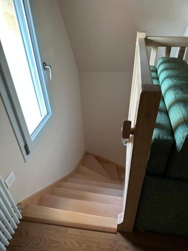 a staircase in a room with a green couch at La Maison Poulette in Ticheville