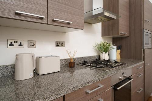 a kitchen with a stove and a counter top at Modern 3BR - Flat Sleeps 8 - Walk to Liverpool St in London