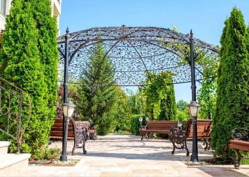 a group of benches in a park with a gate at Cosher - Gardenia Palace Apt 11 in Pomorie