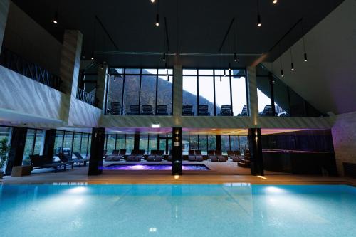 a large swimming pool in a building with windows at Nedei Hotel&Spa Transalpina in Martinie