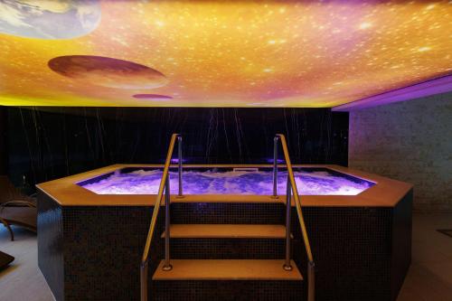 a hot tub in a room with a ceiling at Nedei Hotel&Spa Transalpina in Martinie