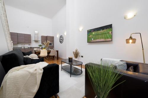 a living room with couches and a tv on the wall at Modern 3BR - Flat Sleeps 8 - Walk to Liverpool St in London
