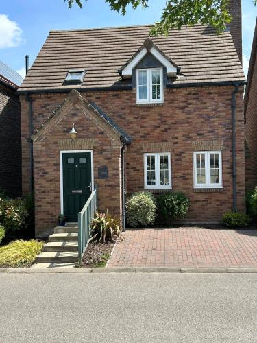 a red brick house with a green door at Hotdog House Filey Detached Pet Friendly Eco-House in Hunmanby