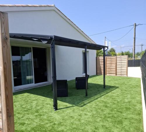 awning on a lawn in front of a house at LA NUIT DES SECRETS Love Room 4 étoiles avec Jacuzzi et Sauna in Roquebrune-sur-Argens