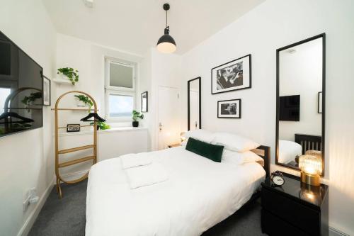 a bedroom with a white bed and a mirror at Princess Street Studios in Dundee