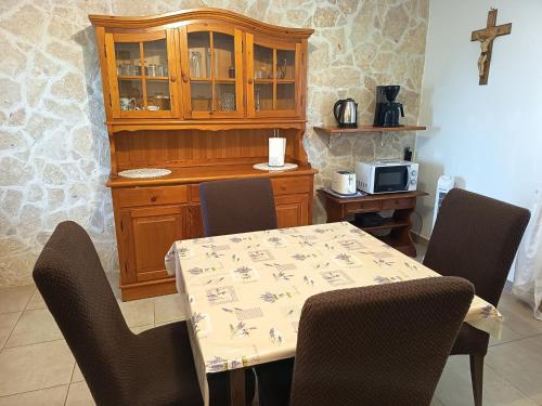 a dining room with a table and chairs and a cross at Villa Irina in Poličnik