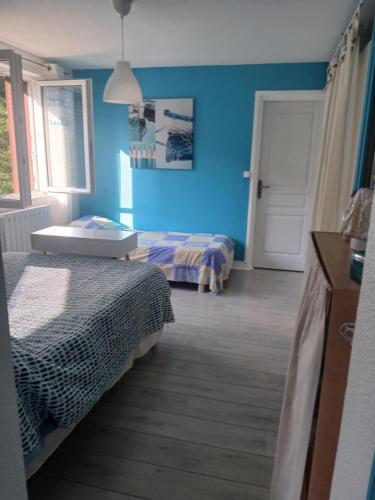 a bedroom with two beds and a blue wall at bord de rivière in Accons